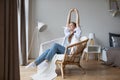 Happy calm young woman relaxing closed her eyes on cozy chair in living room Royalty Free Stock Photo