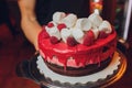 Happy Canada Day celebration cake with flags, marshmallow and candy decorations on a red cake stand on a white table