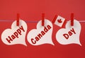 Happy Canada Day message greeting with the Canadian maple leaf flag hanging from pegs on a line