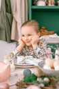 Happy candid little kid four year old girl bored with hands fists in face ready and waiting for lunch or dinner of springtime East