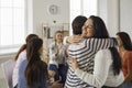 Happy young women hugging each other in support group meeting or therapy session Royalty Free Stock Photo