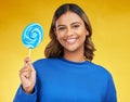 Happy, candy and portrait of a woman, lollipop and positive girl on a yellow studio background. Face, female person or