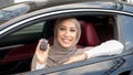 Muslim woman showing auto keys, sitting on driver`s seat Royalty Free Stock Photo