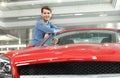 Happy car ownner. Handsome young men leaning on his new car at t Royalty Free Stock Photo