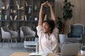 Happy carefree African American woman stretching hands at workplace Royalty Free Stock Photo