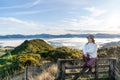 Happy carefree asian woman enjoying nature with layers of mountains and the mist in the morning at The peak of Bank Peninsula, Royalty Free Stock Photo