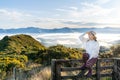 Happy carefree asian woman enjoying nature with layers of mountains and the mist in the morning at The peak of Bank Peninsula, Royalty Free Stock Photo