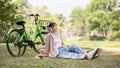 A happy and carefree Asian woman is listening to music on her headphones while chilling in a park Royalty Free Stock Photo