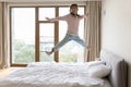 Happy carefree little child jumping on bed mattress at home Royalty Free Stock Photo
