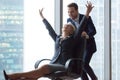 Happy carefree middle-aged businesswoman enjoying office activity riding on chair Royalty Free Stock Photo