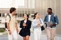Happy carefree multiethnic students walking by street, have conversation Royalty Free Stock Photo