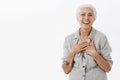 Happy carefree old woman satisfied with how life going. Joyful charming senior lady with grey hair in loose shirt