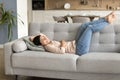 Happy carefree relaxed Indian woman resting on cozy sofa