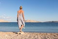 Happy carefree woman enjoying late afternoon walk on white pabbled beach on Pag island, Croatia Royalty Free Stock Photo