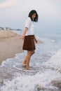 Happy carefree woman walking barefoot in cold sea waves on  sandy beach, enjoying tranquil evening Royalty Free Stock Photo