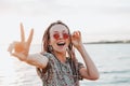 Happy carefree young woman with african braids in pink round sunglasses enjoy her life on beach, hippie style, summer Royalty Free Stock Photo