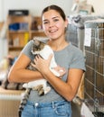 Happy caring young girl holding cat in animal shelter
