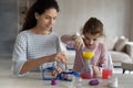 Happy mother making experiment with daughter at home. Royalty Free Stock Photo