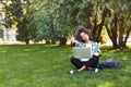 Cheerful young woman using laptop in park Royalty Free Stock Photo