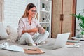 Happy casual beautiful woman working on a laptop sitting on the bed in the house Royalty Free Stock Photo