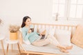 Happy casual beautiful woman working on a laptop sitting on the sofa in the house Royalty Free Stock Photo