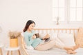 Happy casual beautiful woman working on a laptop sitting on the sofa in the house Royalty Free Stock Photo