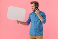 Happy casual guy holding speech bubble and talking on the phone Royalty Free Stock Photo