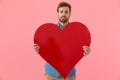 Happy casual guy smiling and holding big red heart Royalty Free Stock Photo