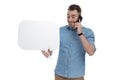 Happy casual holding blank speech bubble and talking on phone Royalty Free Stock Photo