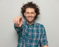 happy casual man with glasses smiling and pointing finger forward Royalty Free Stock Photo