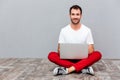 Happy casual man sitting on the floor with laptop Royalty Free Stock Photo