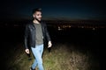 Happy casual man wearing leather jacket walks on grass field Royalty Free Stock Photo