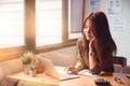 Happy casual young businesswoman working on a laptop computer in office at her home. Working at home concept Royalty Free Stock Photo