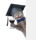 Happy Cat with black graduation cap holding a wineglass behind a white and blank banner. isolated on white background Royalty Free Stock Photo