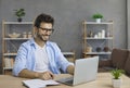 Happy Caucasian adult male student studying independently at home online using laptop. Royalty Free Stock Photo