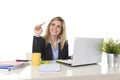 Happy Caucasian blond business woman working on laptop computer at modern office desk Royalty Free Stock Photo