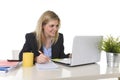 Happy Caucasian blond business woman working on laptop computer at modern office desk Royalty Free Stock Photo
