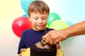 Happy caucasian boy celebrates birthday by holding a chocolate cake in his hands with candle and enjoying holiday Royalty Free Stock Photo