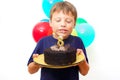 Happy caucasian boy celebrates birthday by holding a chocolate cake in his hands with candle and enjoying holiday Royalty Free Stock Photo