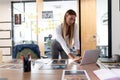 Happy caucasian businesswoman standing at desk having video call conversation using laptop Royalty Free Stock Photo