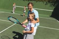 Happy caucasian couple with daughter and son outdoors, playing tennis on tennis court Royalty Free Stock Photo