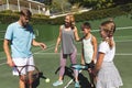 Happy caucasian couple with daughter and son outdoors, playing tennis on tennis court Royalty Free Stock Photo