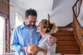 Happy caucasian couple holding piggy bank to save money to make their future dreams come true. Loving man and woman embracing each