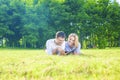 Happy Caucasian Couple in Love Lying on the Grass Outdoors. Read Royalty Free Stock Photo