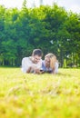 Happy Caucasian Couple in Love Lying on the Grass Outdoors. Read Royalty Free Stock Photo