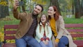 Happy Caucasian couple parents mother father little cute daughter child kid girl making selfie photo with smartphone Royalty Free Stock Photo