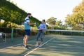 Happy caucasian couple playing tennis making a toast with water bottles on outdoor tennis court