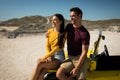 Happy caucasian couple sitting on beach buggy by the sea smiling Royalty Free Stock Photo