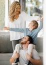 Happy caucasian family bonding at home. Excited little boy sitting on his fathers shoulders and holding his mothers Royalty Free Stock Photo