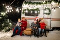 Happy Caucasian family celebrating Christmas outdoors. Parents and three sons travel in a camper. Royalty Free Stock Photo